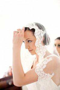 Bride putting on veil